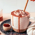 Mug of creamy tahini hot chocolate topped with whipped cream