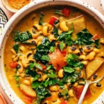 Creamy curried black eyed pea soup in a bowl with kale