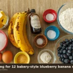 Flat-lay of blueberry banana muffin ingredients on wood