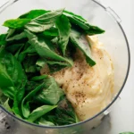 Creamy basil sauce in a white bowl with basil garnish