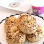 Glazed golden high-protein gluten-free bagels on a cooling rack