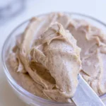 Whipped cinnamon honey butter scooped from a glass bowl