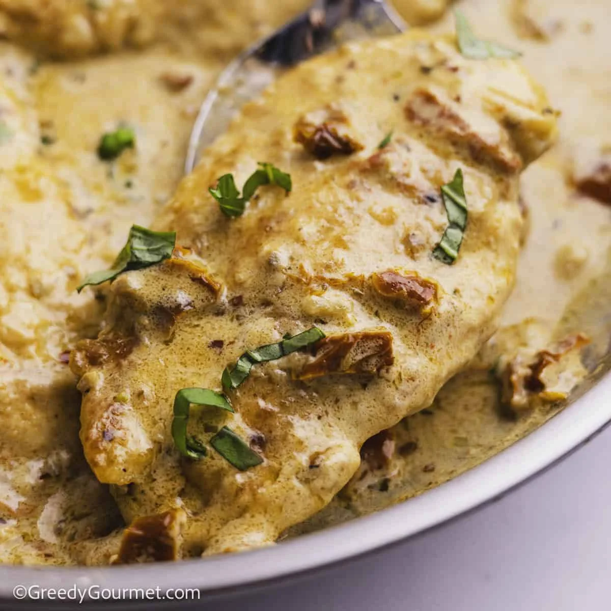 Creamy marry me chicken with sun-dried tomato sauce in a skillet