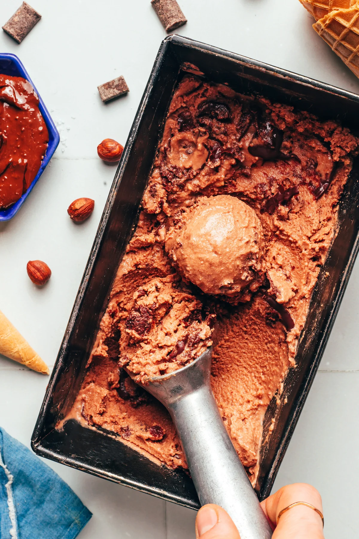Chocolate hazelnut ice cream swirled in a metal pan with cones