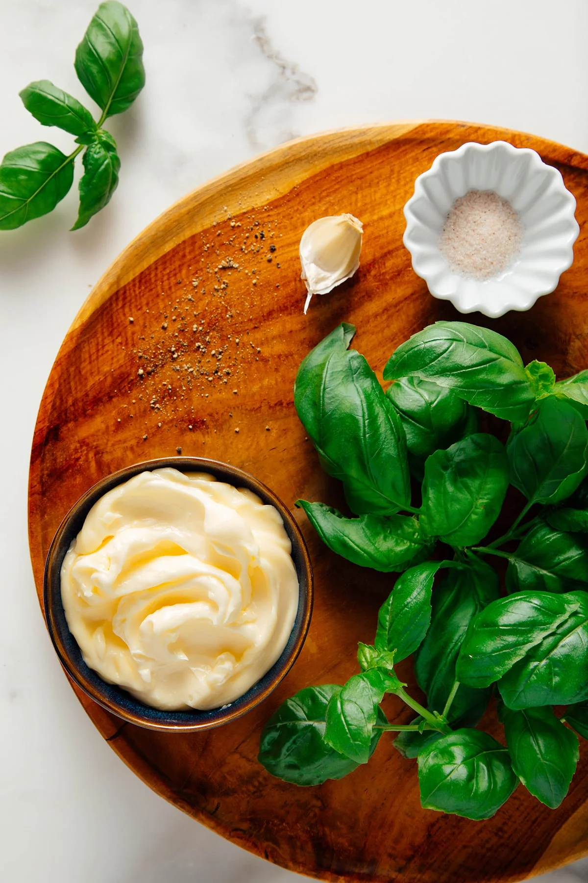 Fresh basil leaves arranged on a wooden surface