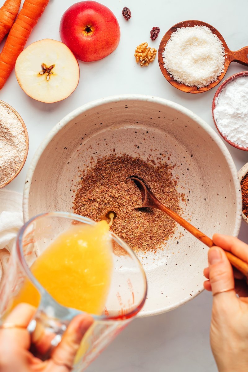 Hands mixing muffin batter in a large bowl