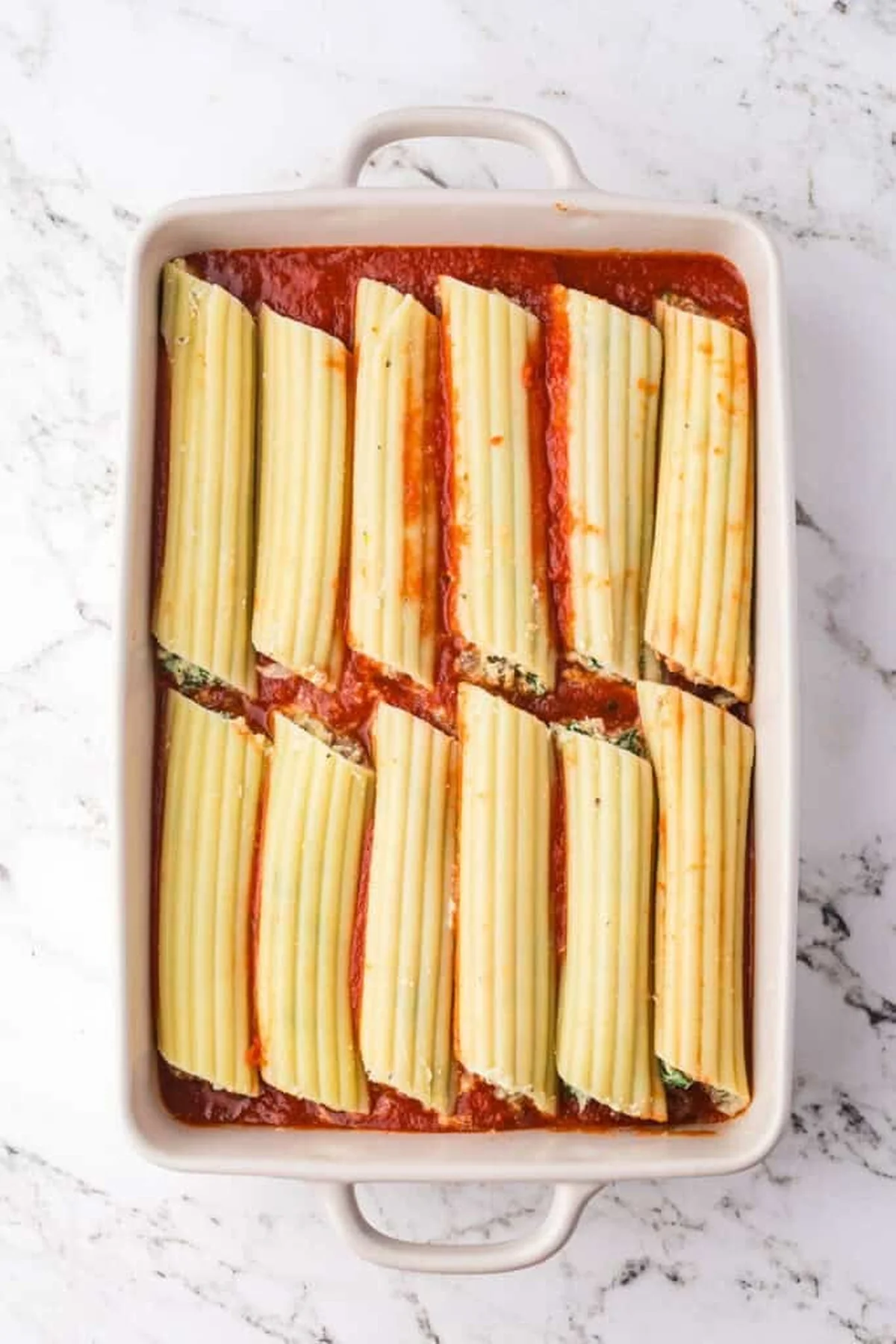 Baked manicotti casserole plated with melted cheese