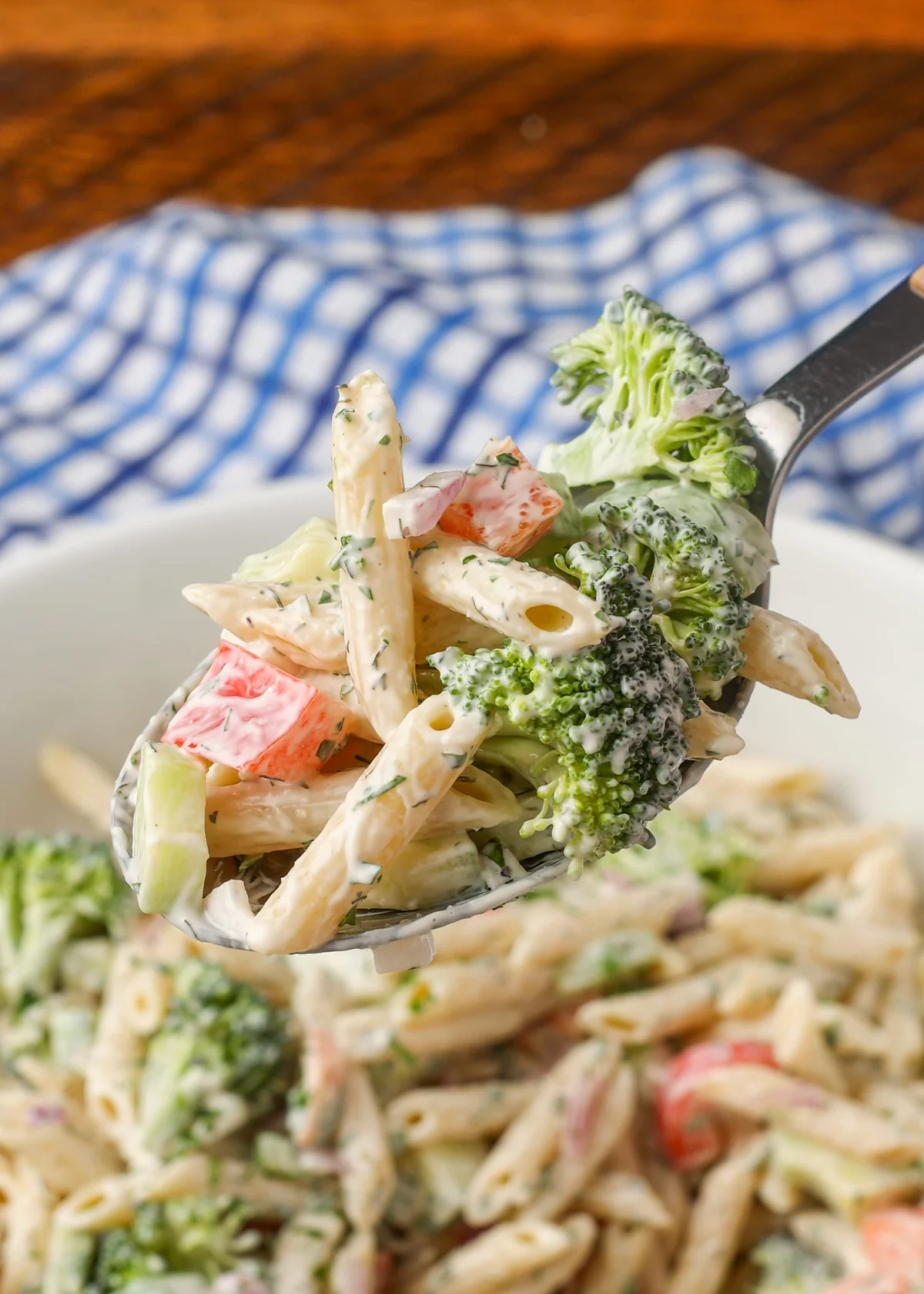 Close-up spoonful of creamy ranch pasta salad with fresh vegetables
