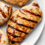 Grilled chicken breasts with dark grill marks on a plate