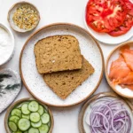 Smoked salmon toast ingredients laid out on a light counter