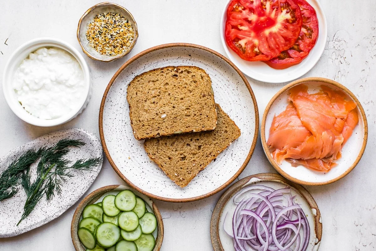 Smoked salmon toast ingredients laid out on a light counter