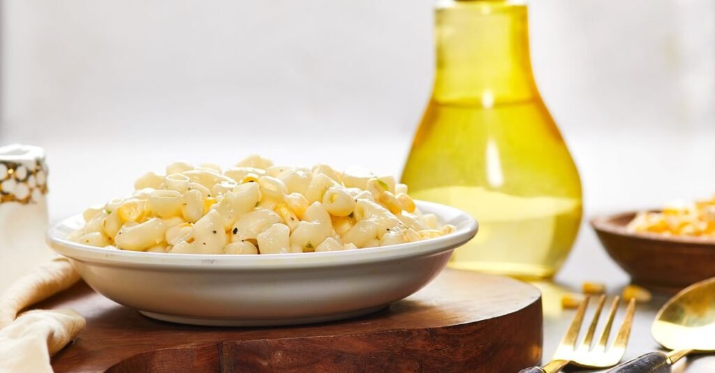 Creamy macaroni salad in a bowl on a wooden board
