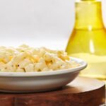 Creamy macaroni salad in a bowl on a wooden board