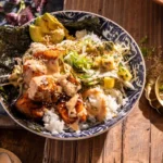 Layered bang bang salmon bowls with pineapple slaw and sauce