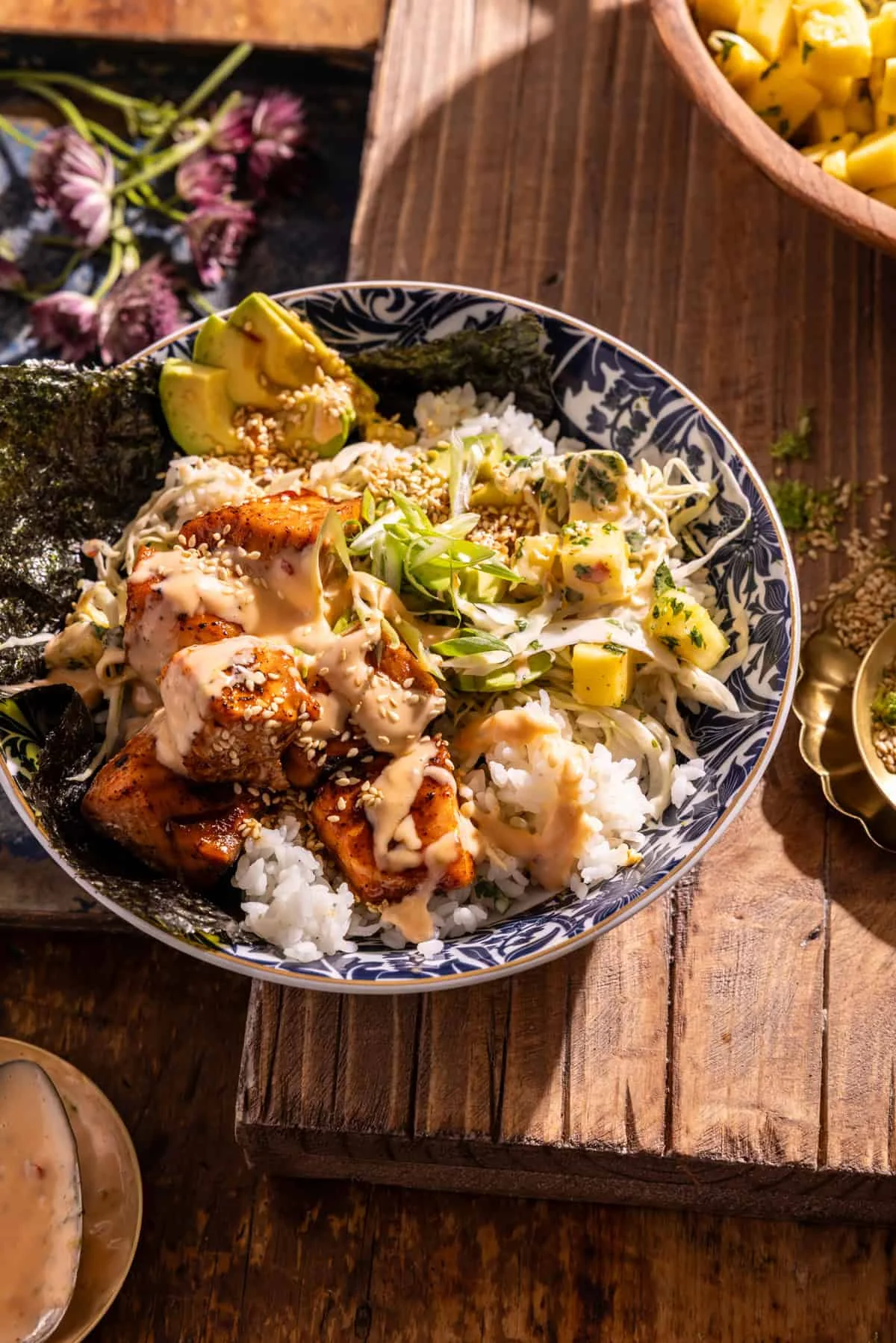 Layered bang bang salmon bowls with pineapple slaw and sauce