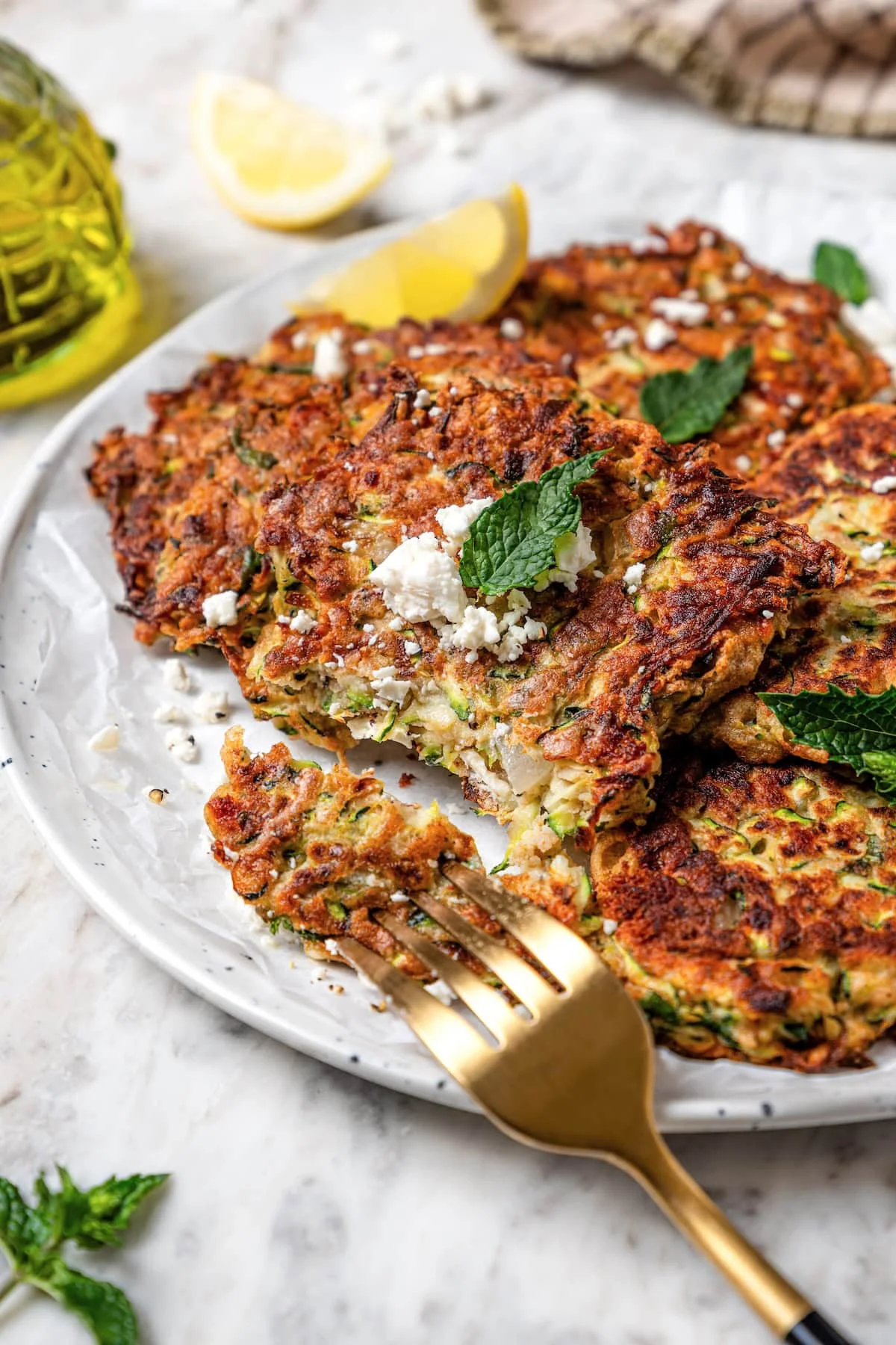 Golden zucchini fritters with feta and fresh mint on a plate