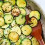 Golden sautéed zucchini rounds with Parmesan in a serving dish