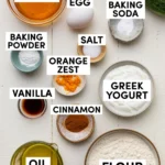 Labeled baking ingredients for Greek yogurt zucchini bread in a flat lay