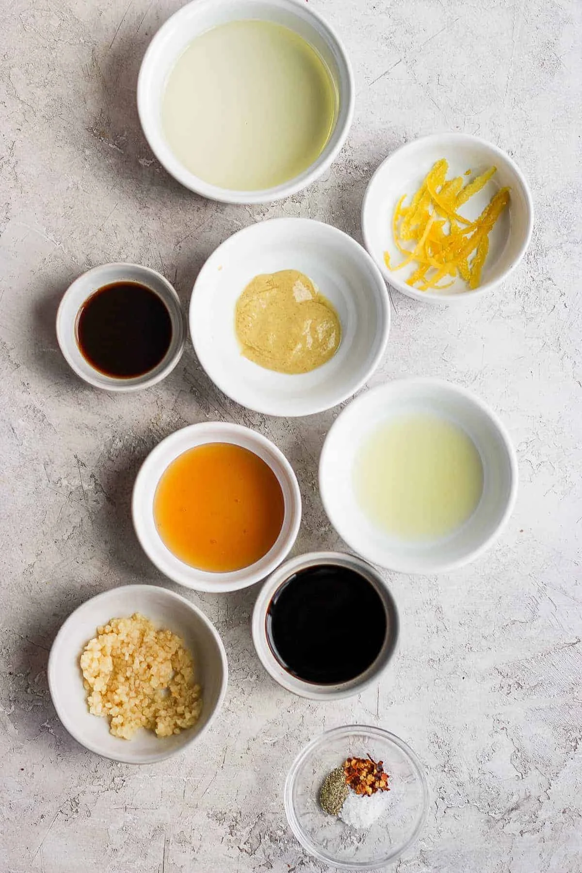 Marinade ingredients in small bowls on a gray surface