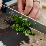 Finely diced jalapeño and white onion on a wooden cutting board