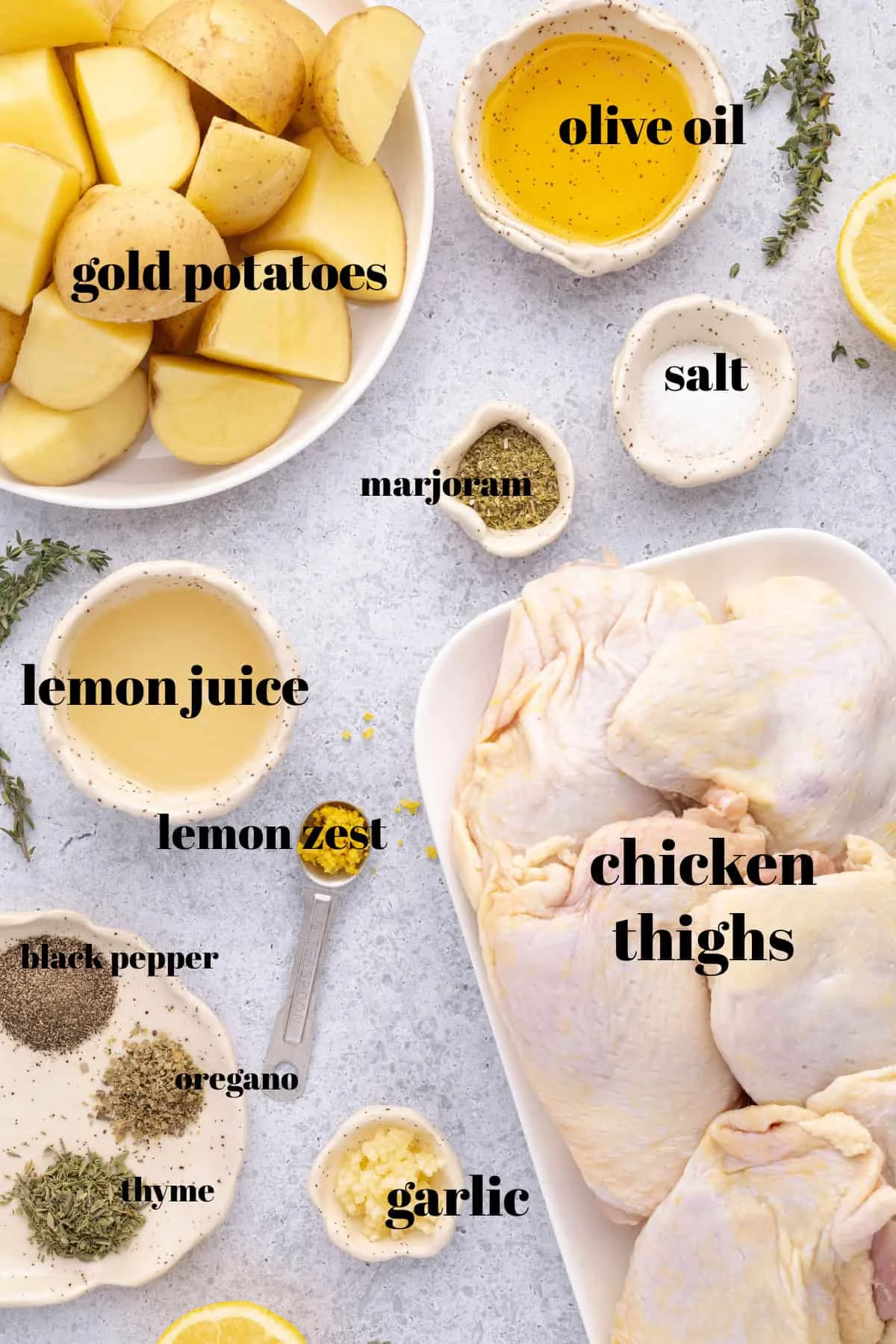 Raw ingredients for Greek chicken and potatoes laid out on a counter