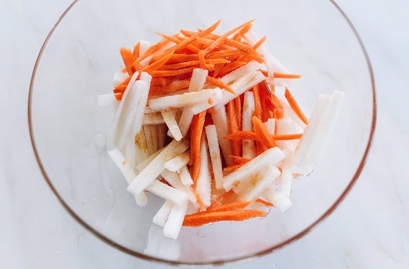 Pickled carrots and daikon tossing in a large bowl