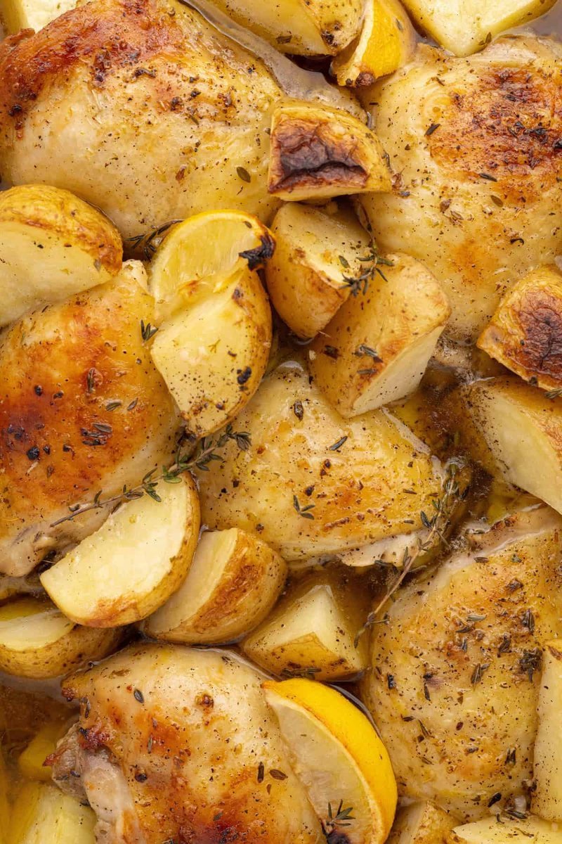 Roasted chicken and potatoes with charred lemon wedges and fresh thyme