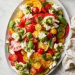 Finished tomato burrata salad with pesto and fresh basil