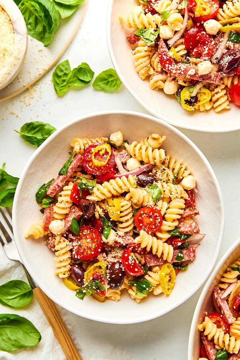 Flat-lay of raw rotini and fresh pasta salad ingredients