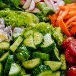 Close-up of sliced cucumber, cherry tomatoes, carrots, and radishes