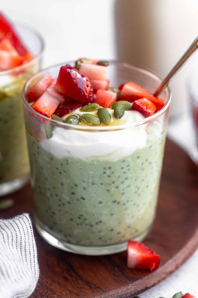 Layered green matcha chia parfait topped with fresh strawberries