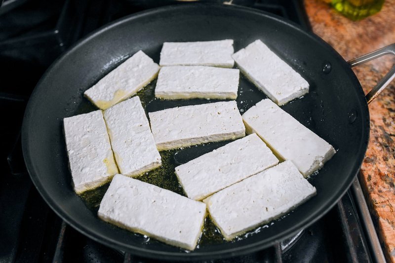 Tofu slices pan-frying until golden and crisp in oil