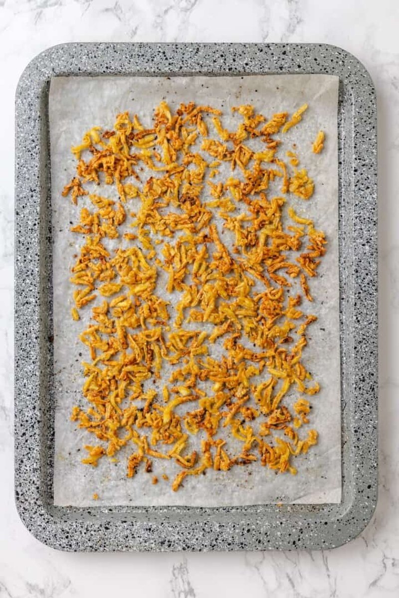 Golden crispy baked tofu spread on baking sheet