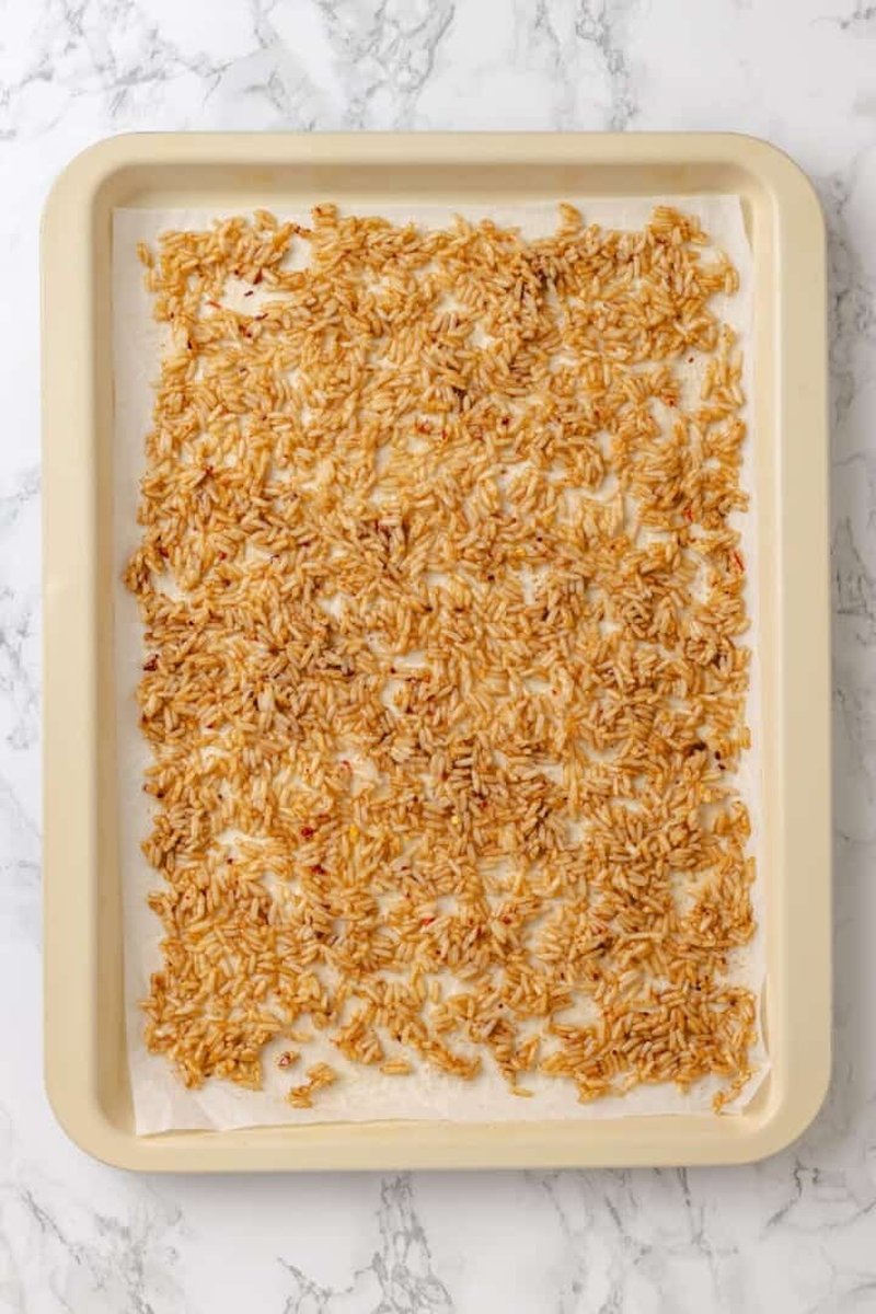 Crispy golden baked rice on parchment-lined baking sheet