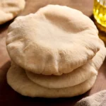 Stack of freshly baked pita bread on a wooden board