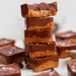 Stack of two-layer protein bites with chocolate topping and flaky salt