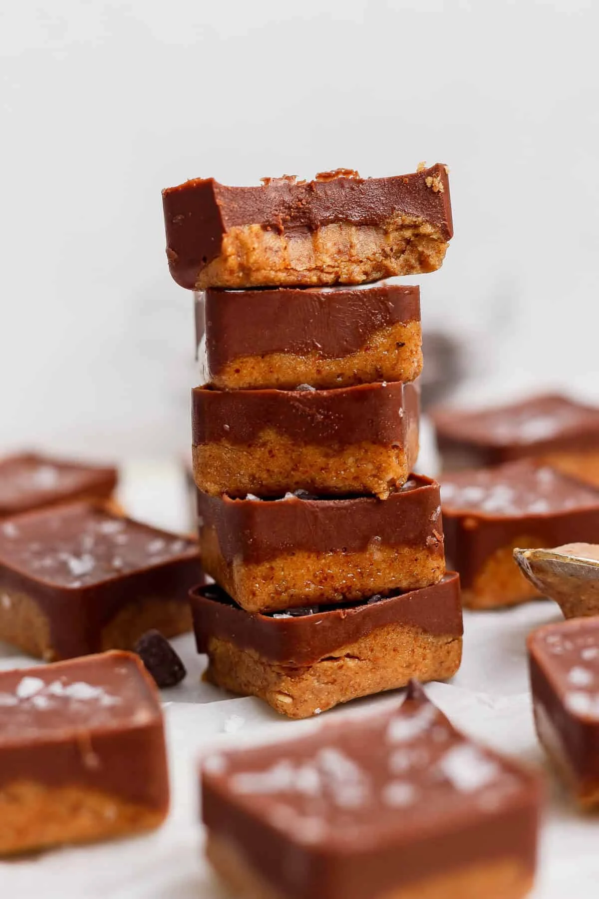 Stack of two-layer protein bites with chocolate topping and flaky salt