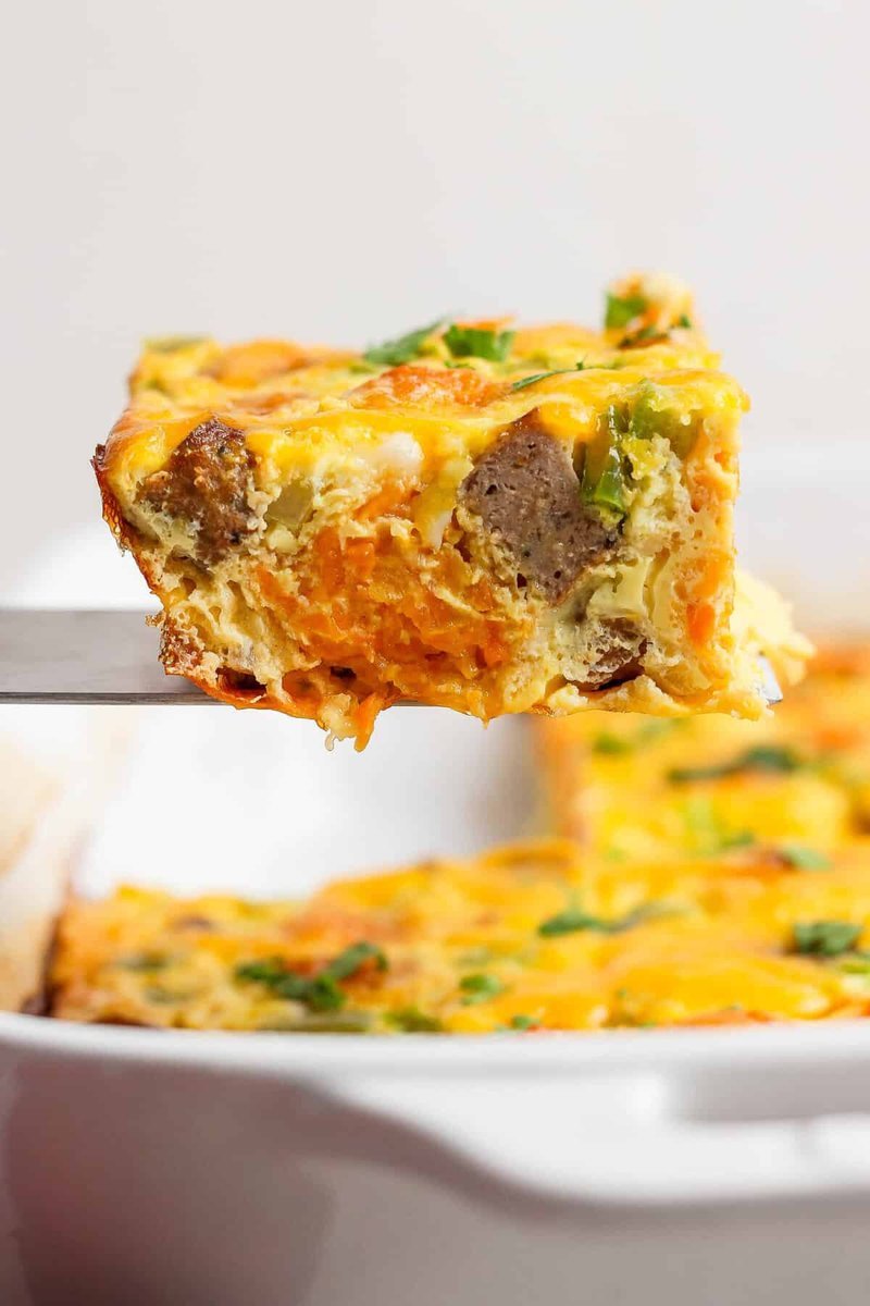 Spatula lifting a square from the baked casserole
