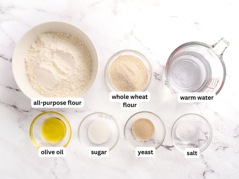 Pita dough ingredients laid out in labeled bowls