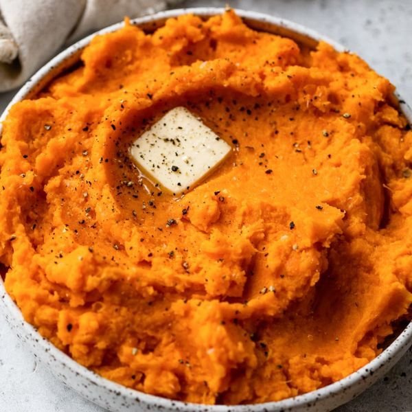 Creamy slow cooker mashed sweet potatoes topped with melting butter and cracked black pepper