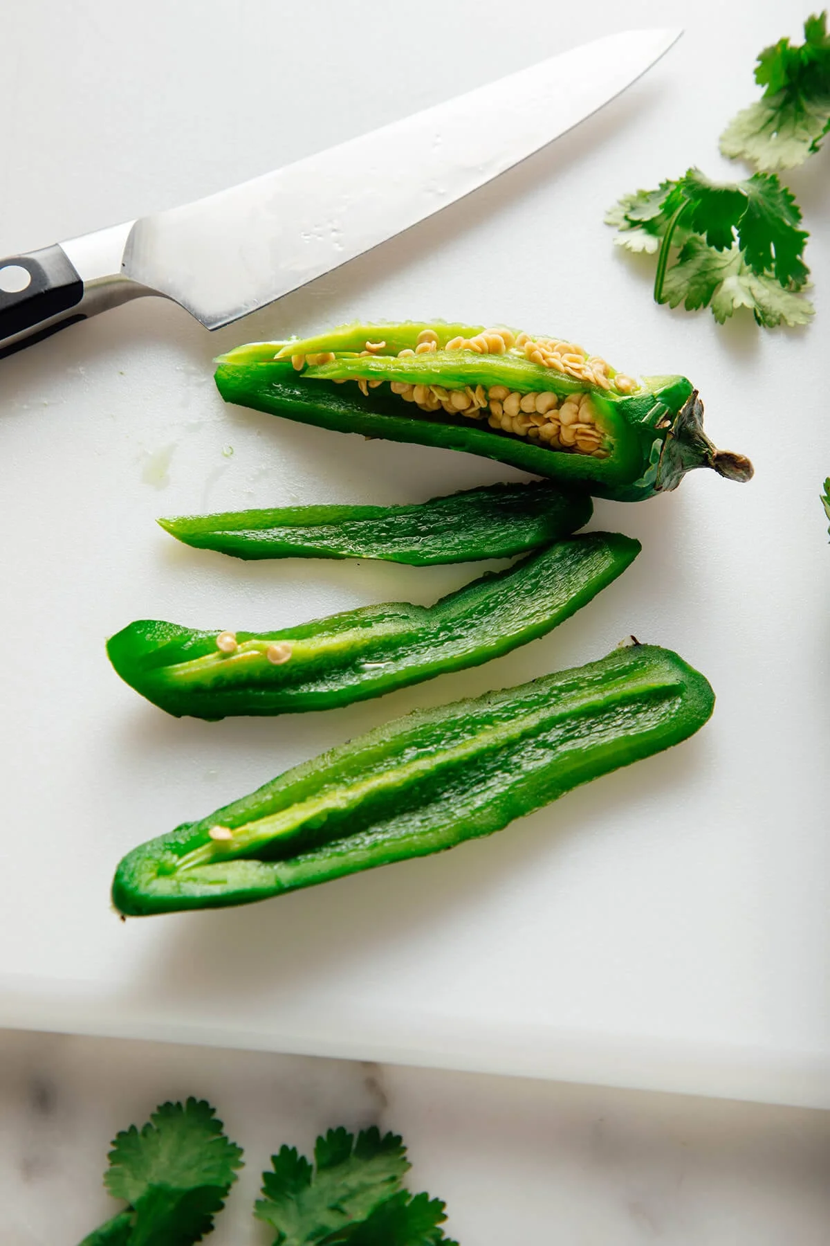 Green sauce blending in a food processor bowl